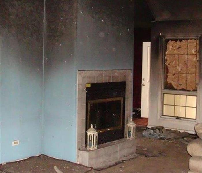 soot covered walls by fireplace, boarded window